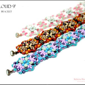 May include: Three beaded bracelets in a row, each with a unique design. The top bracelet is white with pink floral accents, the middle one is orange and black, and the bottom one is purple and turquoise. The bracelets are labeled 'CLOUD 9' and 'BRACELET'.