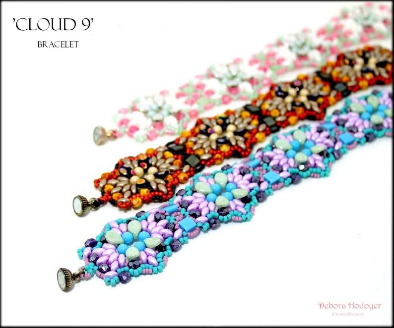May include: Three beaded bracelets in a row, each with a unique design. The top bracelet is white with pink floral accents, the middle one is orange and black, and the bottom one is purple and turquoise. The bracelets are labeled 'CLOUD 9' and 'BRACELET'.