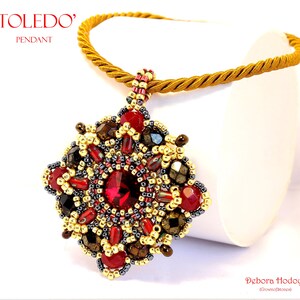 Può includere: Collana con pendente dettagliato con un pendente dai toni gioiello in rosso, oro e nero. Il pendente ha una pietra rossa centrale ed è sospeso a un cordoncino dorato intrecciato. Il testo "TOLEDO" e "PENDANT" è visibile.