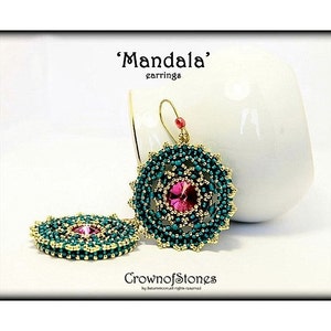 May include: A pair of 'Mandala' earrings. The earrings feature a central pink gemstone surrounded by teal beads and gold accents. The design is circular, with a beaded pattern. The earrings are displayed on a white background.