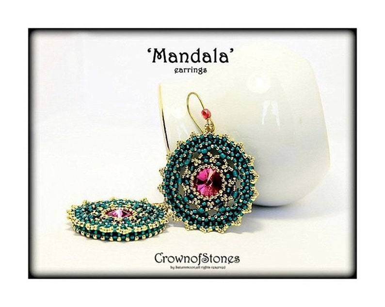May include: A pair of 'Mandala' earrings. The earrings feature a central pink gemstone surrounded by teal beads and gold accents. The design is circular, with a beaded pattern. The earrings are displayed on a white background.