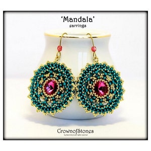 May include: A pair of 'Mandala' earrings. Each earring features a central pink gemstone surrounded by teal beads and gold-colored accents. The earrings hang from gold-colored hooks with small red beads. The text 'Mandala' earrings is at the top.