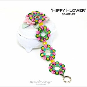 Può includere: Un braccialetto di perline con un design floreale. Il braccialetto presenta perline rosa, verdi, gialle e iridescenti disposte a forma di fiori. Il testo sull'immagine recita "'Hippy Flower' Bracelet".
