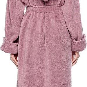 May include: A long, dusty rose-colored hooded robe with a matching belt. The robe has long sleeves with folded cuffs. The model is wearing the robe, standing with their back to the camera.