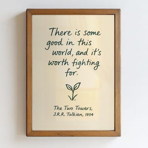 May include: A framed print with a light beige background and dark green text. The text reads "There is some good in this world, and it's worth fighting for." Below the quote is a small plant illustration and the text "The Two Towers, J.R.R. Tolkien, 1954."