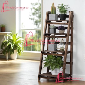 May include: A dark brown wooden plant stand with multiple shelves, displaying various potted plants including cacti and leafy greens. The stand is leaning against a white wall near a window, creating a natural, indoor garden aesthetic. The text "WheelsCommerce ONLINE SHOP" is visible.