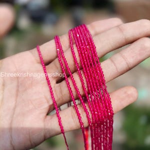 May include: Strands of vibrant fuchsia-colored gemstone beads. The beads are small, faceted, and strung together, creating a delicate and sparkling appearance. The image shows multiple strands, suggesting a collection or a supply for jewelry making.