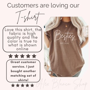 May include: Brown t-shirt with the word "Besties" and "EST. 2026" printed in white. The shirt is part of a customer review with text that says the fabric is high quality and the color is true to what is shown online.