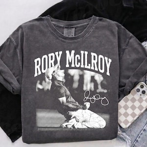 May include: A set of three ceramic mugs with a speckled, matte finish. The mugs are in shades of cream, light gray, and dark gray. Each mug has a simple, minimalist design and a rounded handle. The mugs are likely for coffee or tea.