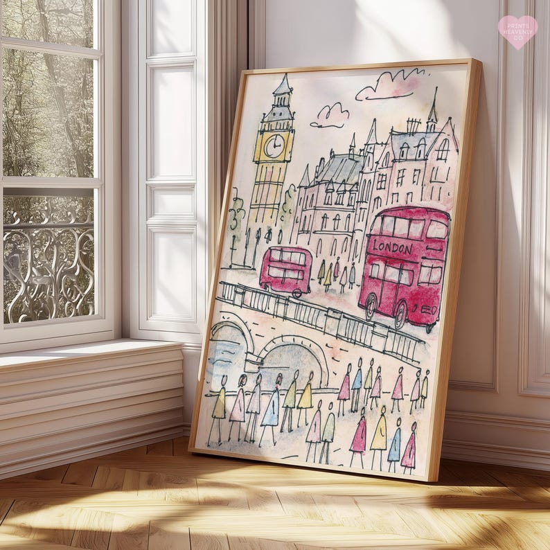 May include: Watercolor print of London featuring Big Ben, red double-decker buses, and a bridge with pedestrians. The artwork has a light wood frame and is displayed near a window.