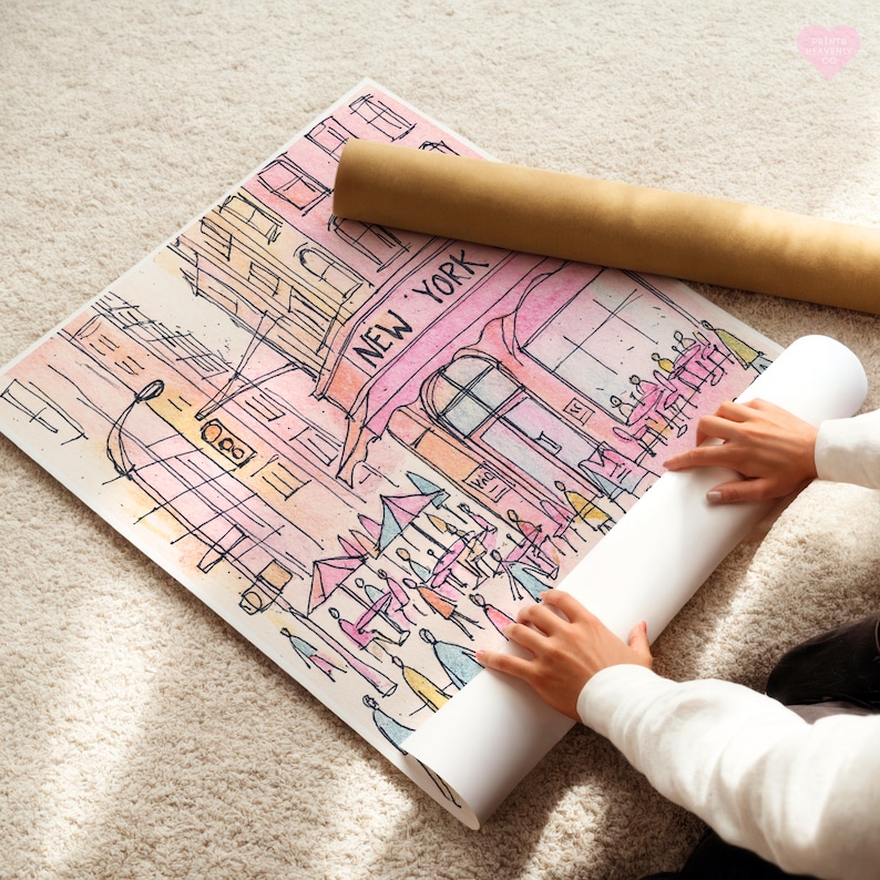 May include: A watercolor print of a New York street scene, featuring a pink cafe with the text "NEW YORK". The artwork is rolled up with a brown paper tube.
