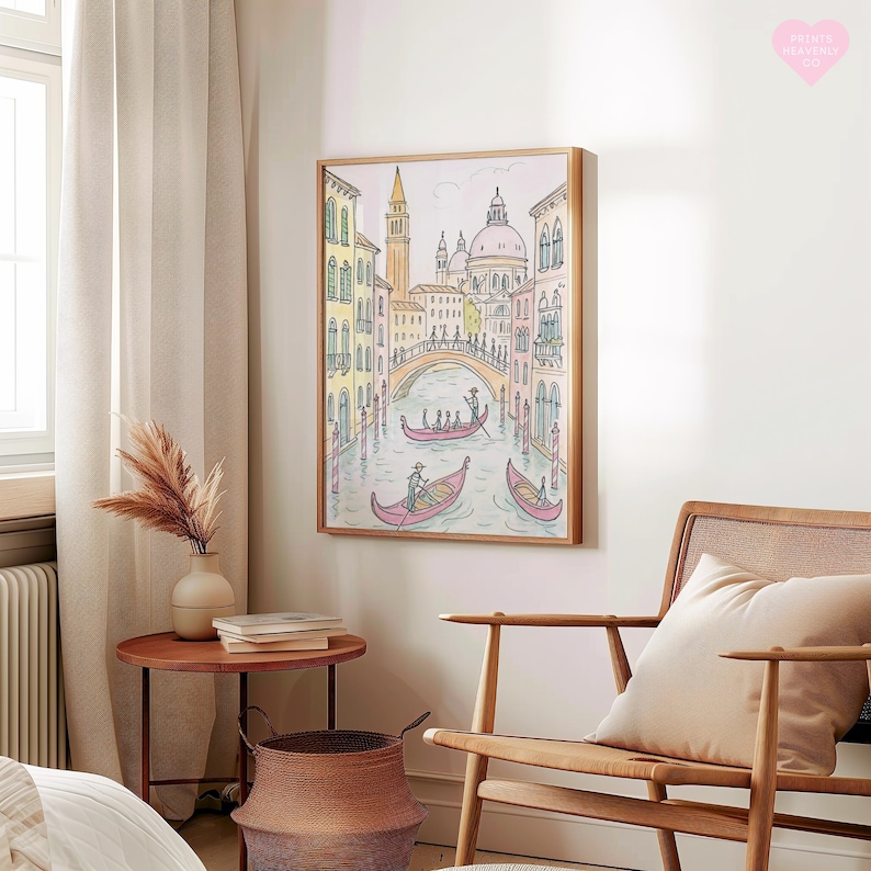 K&ouml;nnte beinhalten: Ein gerahmter Kunstdruck, der eine farbenfrohe venezianische Kanalszene darstellt. Das Kunstwerk zeigt Gondeln, eine Br&uuml;cke und Geb&auml;ude in Gelb-, Rosa- und Blaut&ouml;nen. Der Druck wird an einer wei&szlig;en Wand neben einem Holzstuhl und einem kleinen Beistelltisch gezeigt.