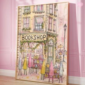 May include: Watercolor print of a quaint bookshop with the word "BOOKSHOP" above the entrance. The building is painted in soft yellows and pinks, with a "SALE" sign in the window. Figures in colorful coats stand in front of the shop.