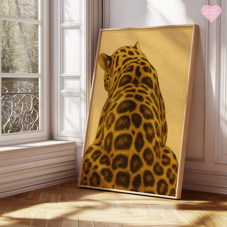May include: A framed art print featuring a detailed illustration of a leopard's back and spotted fur. The artwork is in shades of brown and gold, with a light-colored background. The print is displayed in a room with natural light.
