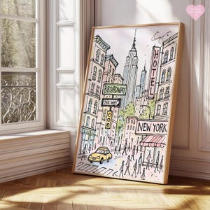 Pu&ograve; includere: Una stampa ad acquerello incorniciata di una scena di strada di New York City. L'opera presenta l'Empire State Building, i cartelli di Broadway, un taxi giallo e la parola "NEW YORK". La stampa ha una cornice in legno chiaro.