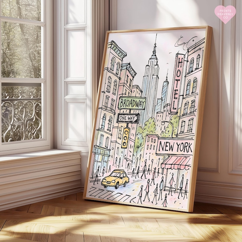 Pu&ograve; includere: Una stampa ad acquerello incorniciata di una scena di strada di New York City. L'opera presenta l'Empire State Building, i cartelli di Broadway, un taxi giallo e la parola "NEW YORK". La stampa ha una cornice in legno chiaro.