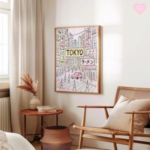 May include: A framed art print depicting a street scene in Tokyo. The artwork features a pink car, pedestrians, and Japanese signage, including the word "TOKYO" and "ラーメン". The color palette includes soft pinks, blues, and greens, with a wooden frame.