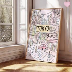 May include: A framed art print depicting a street scene in Tokyo. The artwork features a pink car, pedestrians crossing a street, and Japanese text. The word "TOKYO" is prominently displayed in a yellow sign. The print has a light wood frame.