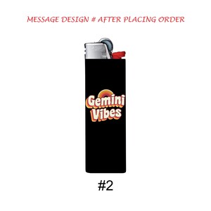 May include: A black lighter with the text "Gemini Vibes" in orange, yellow, and white. The lighter has a silver top and a red button. The number "#2" is at the bottom of the lighter.