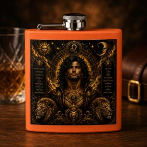 Puede incluir: Una petaca rectangular de color naranja con tapa de rosca plateada. La parte frontal presenta una detallada ilustración en oro y negro de una persona con pelo largo, dos leones, un sol, una luna, el símbolo del zodiaco Leo y texto descriptivo.
