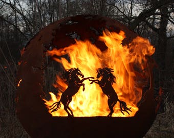 May include: A rusty metal sphere with two horses cut out of the metal, facing each other. The sphere is lit from within by a fire, creating a warm glow.