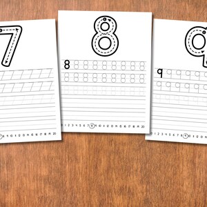 May include: Three white sheets of paper with black numbers 7, 8, and 9, each with dotted lines for tracing and practice lines below. The sheets are on a wooden surface, ideal for educational activities.