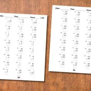 May include: Two white worksheets with math problems, including addition and subtraction, are displayed on a wooden surface. The worksheets have the headings "Date", "Time", and "Score". The score is out of 24.