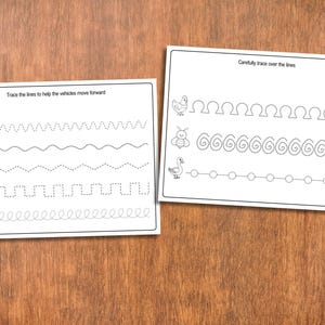 May include: Two white worksheets with black line drawings and text. One worksheet says "Trace the lines to help the vehicles move forward" with vehicle illustrations and dotted lines. The other says "Carefully trace over the lines" with animal illustrations and dotted lines.