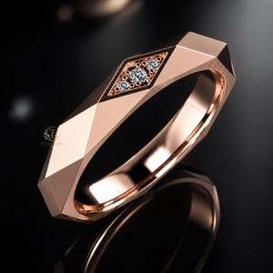 Modern geometric rose gold band ring featuring angular faceted detailing with small round lab grown diamonds set in a central geometric bezel design. Close-up luxury jewelry photo highlights the polished faceted finish, contemporary minimalist craftsmanship, elegant stacking ring style, and refined modern wedding band aesthetic perfect for everyday luxury wear and designer jewelry collections.