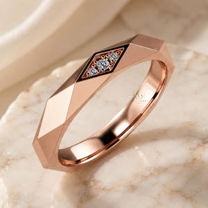 Modern geometric rose gold band ring featuring angular faceted detailing with small round lab grown diamonds set in a central geometric bezel design. Close-up luxury jewelry photo highlights the polished faceted finish, contemporary minimalist craftsmanship, elegant stacking ring style, and refined modern wedding band aesthetic perfect for everyday luxury wear and designer jewelry collections.
