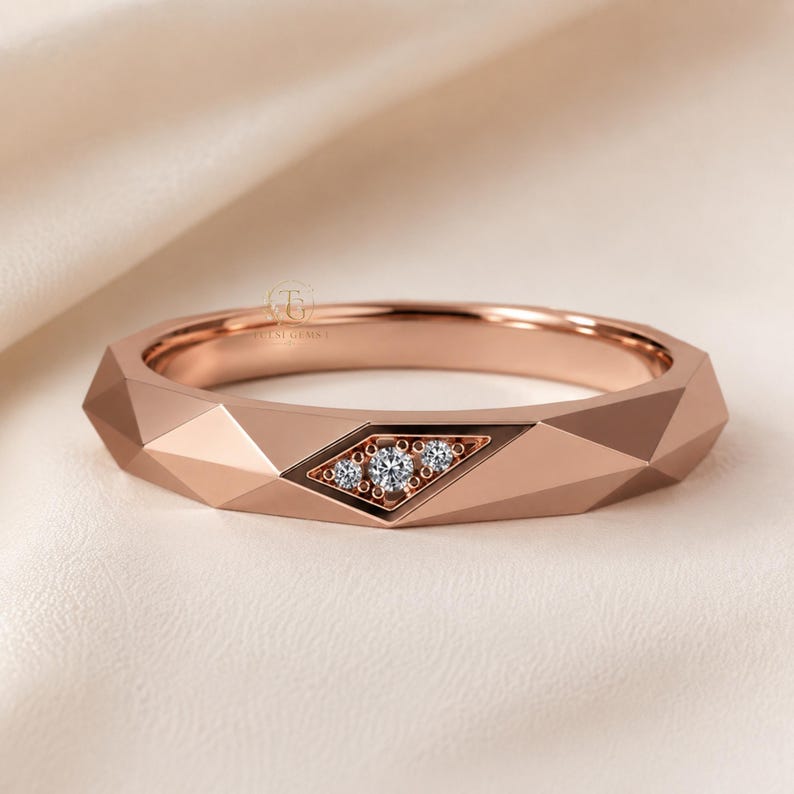 Modern geometric rose gold band ring featuring angular faceted detailing with small round lab grown diamonds set in a central geometric bezel design. Close-up luxury jewelry photo highlights the polished faceted finish, contemporary minimalist craftsmanship, elegant stacking ring style, and refined modern wedding band aesthetic perfect for everyday luxury wear and designer jewelry collections.