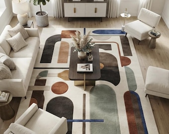 May include: A large area rug featuring a cream-colored background with a geometric pattern of abstract shapes in shades of charcoal, terracotta, sage green, and deep blue. The design includes various arches, rectangles, and circles arranged across the surface.