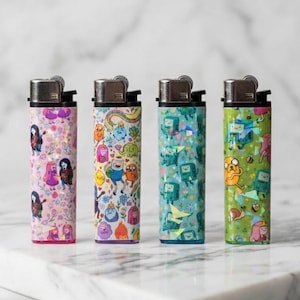 Könnte beinhalten: Vier rechteckige Feuerzeuge mit Metalloberteilen, jedes mit einem eigenen holografischen Muster. Die Designs umfassen rosa, weiße, türkisfarbene und grüne Hintergründe, die mit verschiedenen Zeichentrickfiguren, Blumen und kleinen Wesen verziert sind.