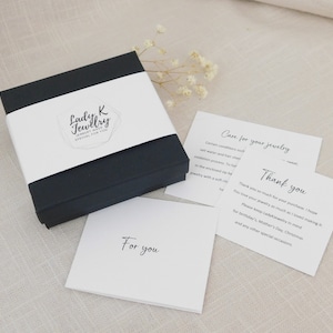 May include: A black jewelry box with a white band displaying "Lady K Jewelry Special for You." Cards nearby say "Care for your jewelry" and "Thank you." A card reads "For you."
