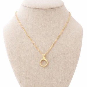 May include: A gold necklace featuring a circular pendant. The pendant is a small, open circle with a clasp at the top, suspended from a fine chain. The necklace is displayed on a beige mannequin.