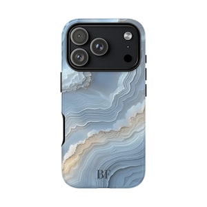 Puede incluir: Funda de teléfono inteligente con un patrón de piedra de ágata azul y beige. La funda tiene un módulo de cámara negro con tres lentes y un flash. Las iniciales "BF" están impresas en la parte inferior de la funda.