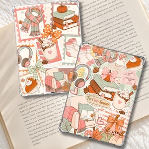 Puede incluir: Dos fundas transparentes para tablet con un patrón repetitivo de ilustraciones otoñales que incluyen libros apilados, calabazas, una taza de chocolate caliente, una bufanda a cuadros, auriculares, un sillón y el texto "Tis Cozy Season".
