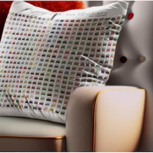 Peut inclure: Coussin carré blanc avec un motif quadrillé de petits rectangles colorés. Le coussin est posé sur une chaise de couleur claire avec des bordures dorées. Le texte sur le coussin indique "...to have 500 colours". Un coussin rouge est en arrière-plan.