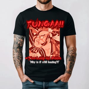 May include: Black t-shirt featuring a red and orange illustration of a stern-faced character with the text "FUNGAAA!!" above and "The Loop of Doom" and "Why is it still loading?!" below. The design has a comic book style.