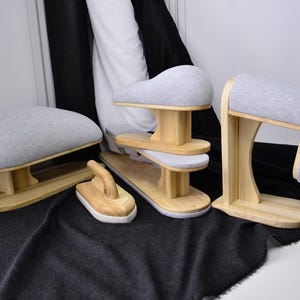 May include: A collection of four wooden tailoring tools for pressing garments, including a tailor's ham, a sleeve board, a clapper, and a point presser. Each tool features light-colored natural wood bases and soft, light gray fabric covers.