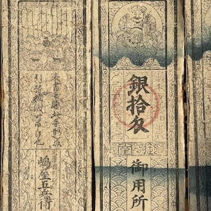 May include: Antique Japanese paper currency with intricate illustrations and calligraphy. The aged paper has a beige tone with black ink. The design includes a figure in a cart, and various Japanese characters. The currency is framed with a decorative border.
