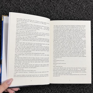 Pu&ograve; includere: Un libro con copertina rigida aperto che mostra due pagine di testo stampato in inglese. La pagina sinistra &egrave; numerata 4 e la pagina destra &egrave; numerata 5. Il testo contiene un passaggio narrativo con personaggi chiamati Harry.