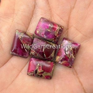 May include: Four rectangular cabochons featuring a vibrant magenta and deep pink base with intricate, metallic gold-colored veining throughout the surface. The stones are polished to a smooth finish and display a complex, marbled pattern of colors.