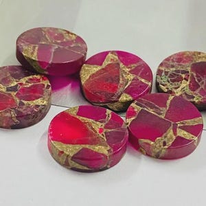 May include: Six circular cabochons featuring a vibrant magenta and deep pink base color with intricate, branching gold-colored veining throughout the surface. Each piece has a smooth, polished finish and a flat, rounded shape for jewelry making.