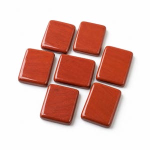 May include: Six rectangular, polished red jasper stones with smooth, rounded edges and a flat surface. Each stone displays a consistent deep brick-red color with subtle, natural grain patterns visible across the opaque, solid mineral material.