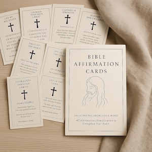 Puede incluir: Un conjunto de tarjetas de afirmación bíblica con fondo crema. Las tarjetas presentan una cruz y texto, con una tarjeta central titulada "Bible Affirmation Cards" y una ilustración de Jesús.