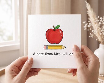 May include: A square white greeting card featuring a colorful illustration of a red apple with a green leaf positioned above a yellow pencil with a pink eraser. The text A note from Mrs. William is printed in black ink at the bottom of the card.