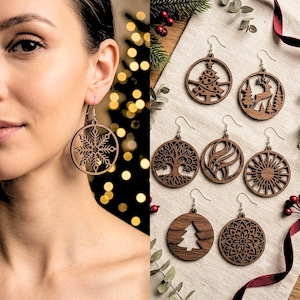 May include: A collection of circular wooden earrings featuring intricate laser-cut designs including a snowflake, a Christmas tree, a deer in a forest, a tree of life, swirling patterns, a sunburst, and a mandala, all with silver-toned metal hooks.