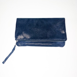 May include: A dark blue leather clutch with a zipper closure and a long strap.