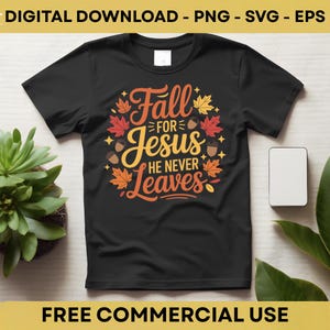 Puede incluir: Camiseta negra con un diseño de temática otoñal. El diseño presenta el texto "Fall for Jesus He Never Leaves" en naranja y amarillo, rodeado de hojas de otoño y bellotas. La camiseta se muestra sobre una superficie clara.